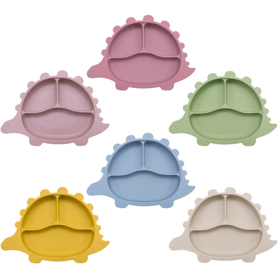 Présentation d'un ensemble d'assiettes pour bébé en silicone en forme de dinosaure, de différentes couleurs et avec des compartiments.