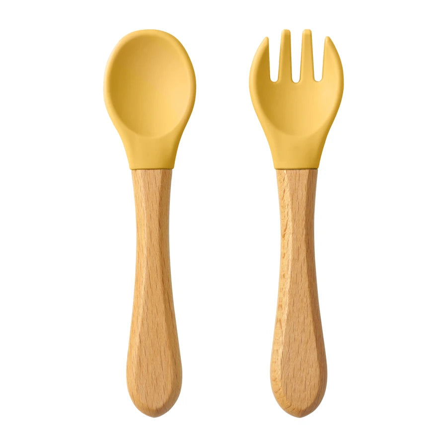 Présentation d’une fourchette et d’une cuillère pour bébé en bois avec des embouts silicone, Jaune 