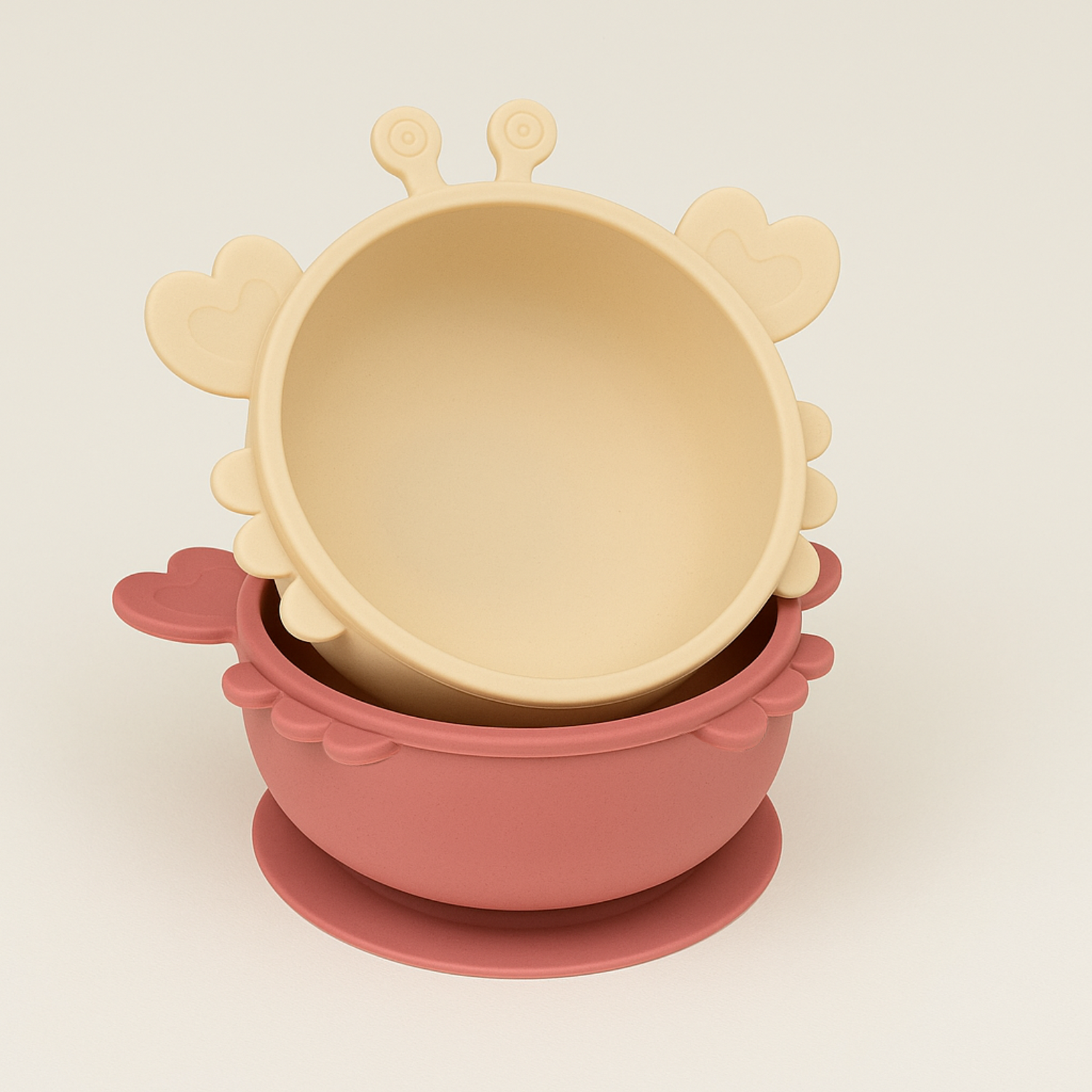 Présentation de deux bol pour enfants en forme de crabe un de couleur rose et un de couleur beige.  