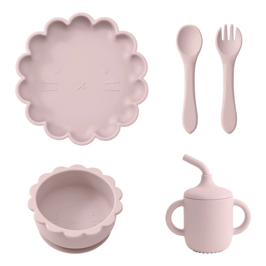 Présentation d'une assiette, d'un bol, d'un gobelet et de couverts pour bébé en silicone rose clair.