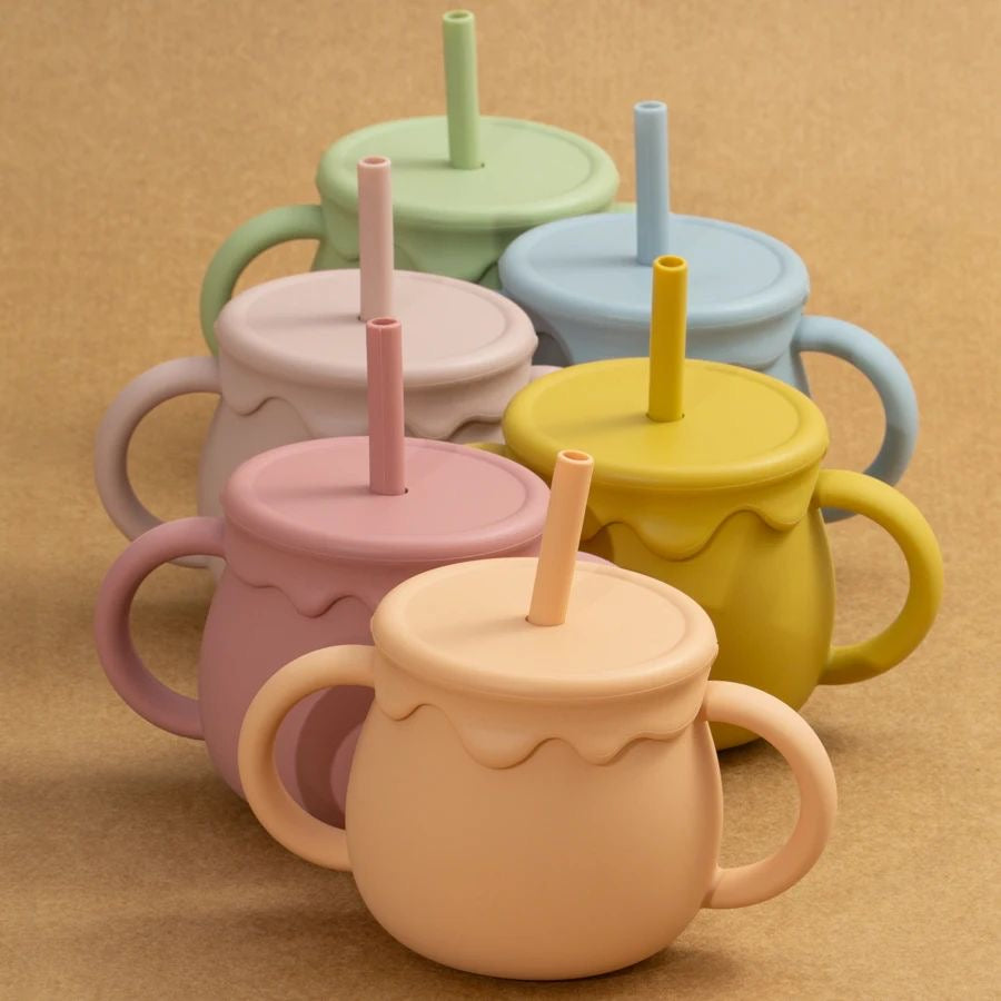 Présentation d'un ensemble de six tasses pour bébé en silicone de différentes couleurs, avec des anses et des pailles colorées.