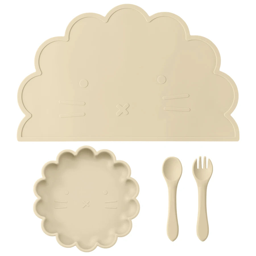 Présentation d'une assiette, un set de table et de couverts pour bébé en silicone beige, sur un fond blanc.