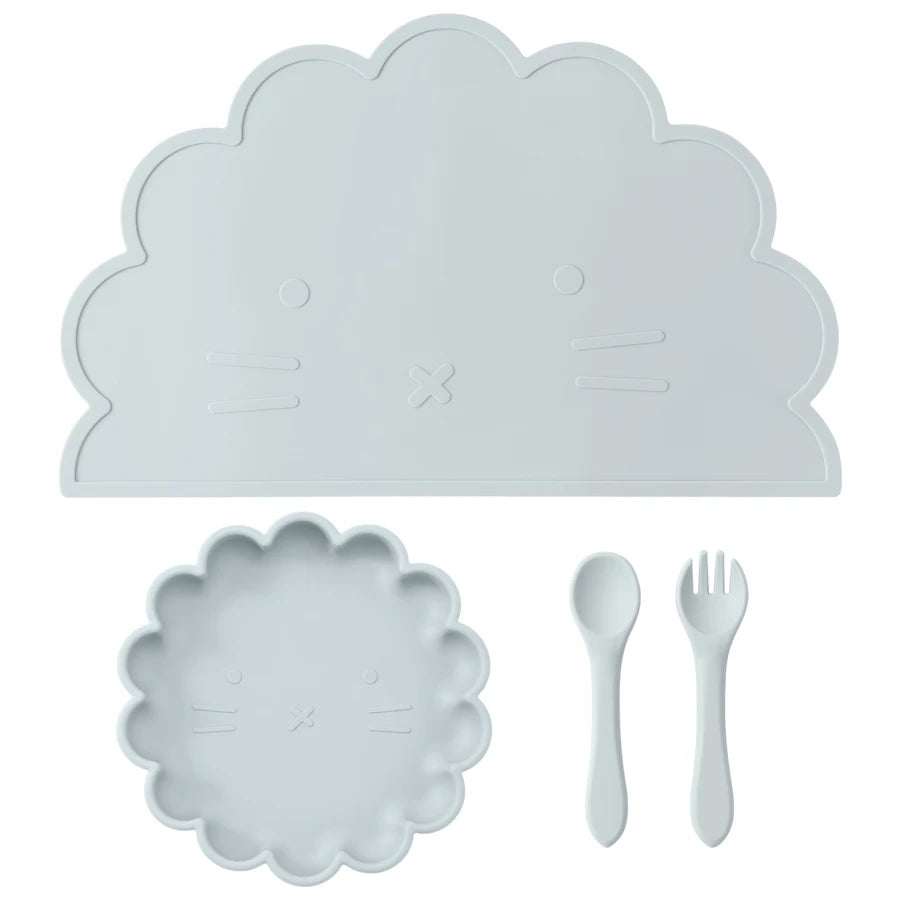Présentation d'une assiette, un set de table et de couverts pour bébé en silicone bleu clair, sur un fond blanc.