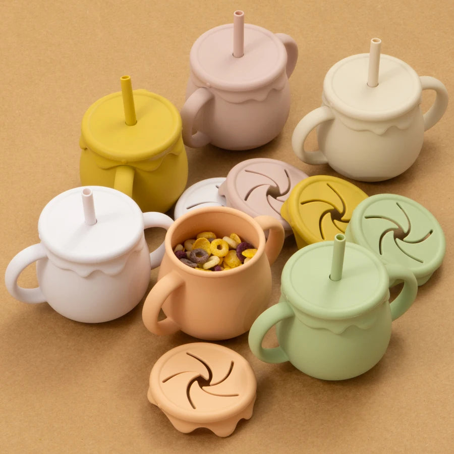 Présentation de tasses d'apprentissage pour bébé en silicone dans une gamme de couleurs différentes, avec des couvercles amovibles.