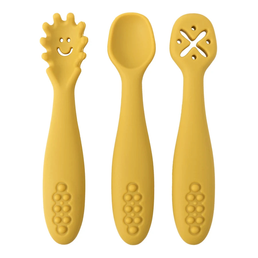 Présentation d'un ensemble de trois cuillères pour bébé jaunes en silicone avec des motifs variés.