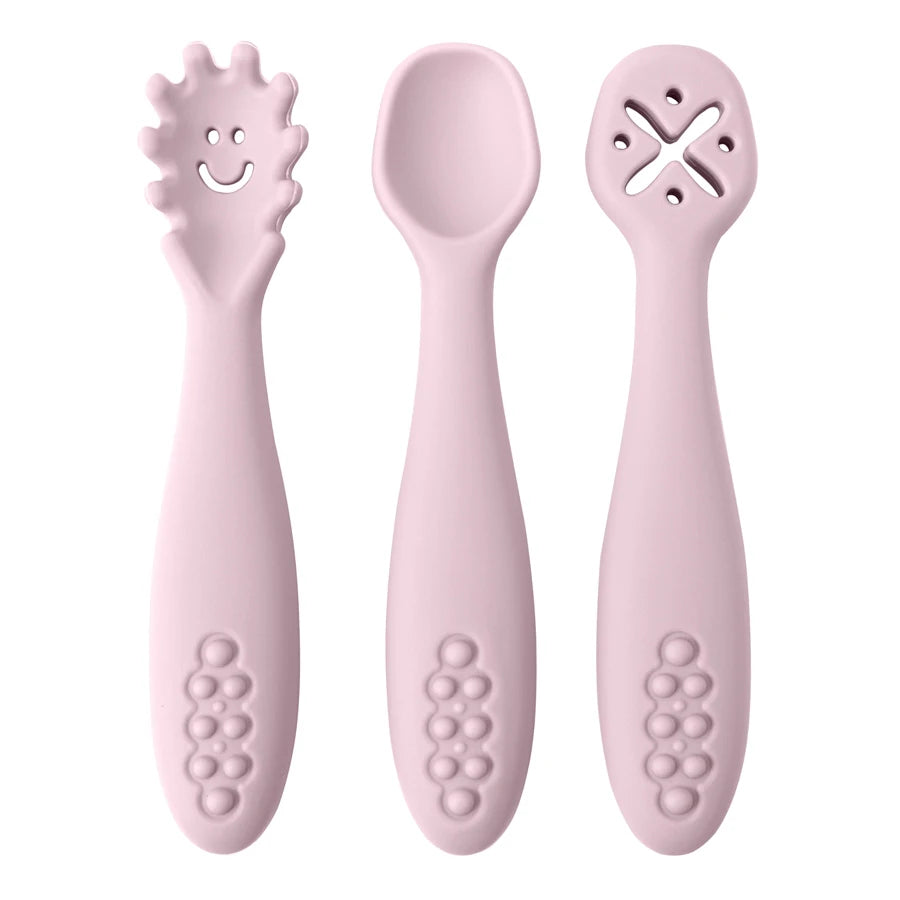 Présentation d'un ensemble de trois cuillères pour bébé rose clair en silicone avec des motifs variés.