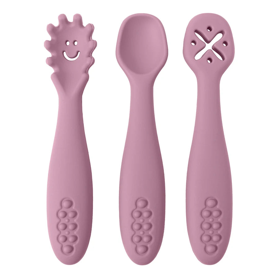 Présentation d'un ensemble de trois cuillères pour bébé rose foncé en silicone avec des motifs variés.
